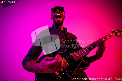 Image of Young african-american jazz musician playing the guitar