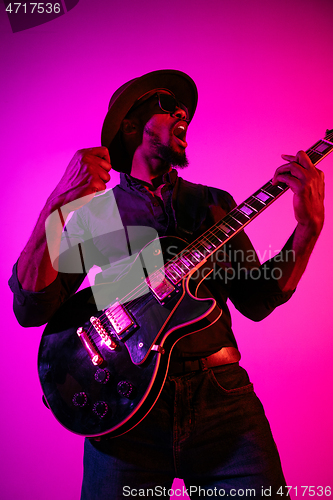 Image of Young african-american jazz musician playing the guitar