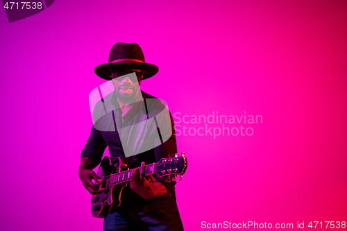 Image of Young african-american jazz musician playing the guitar