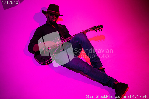 Image of Young african-american jazz musician playing the guitar