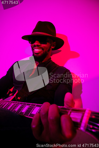 Image of Young african-american jazz musician playing the guitar