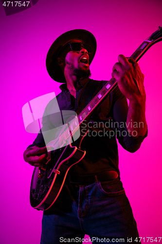 Image of Young african-american jazz musician playing the guitar