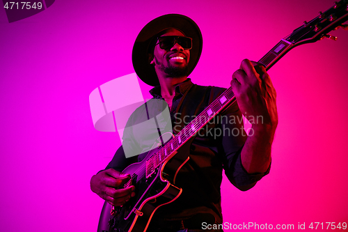 Image of Young african-american jazz musician playing the guitar