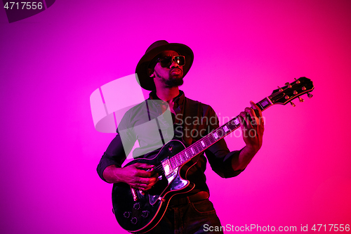 Image of Young african-american jazz musician playing the guitar