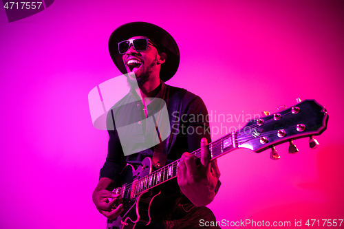 Image of Young african-american jazz musician playing the guitar