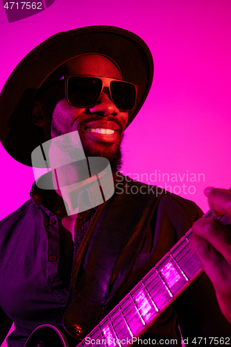 Image of Young african-american jazz musician playing the guitar