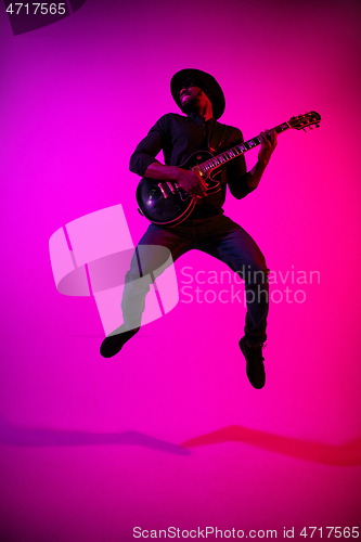 Image of Young african-american jazz musician playing the guitar