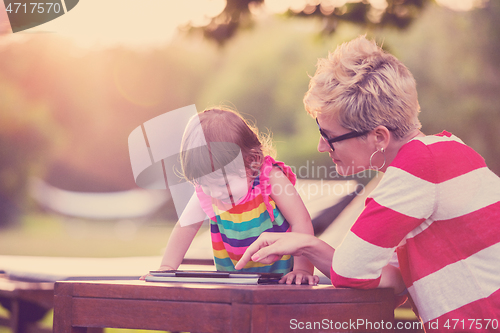 Image of mom and her little daughter using tablet computer