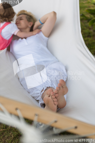 Image of mother and a little daughter relaxing in a hammock