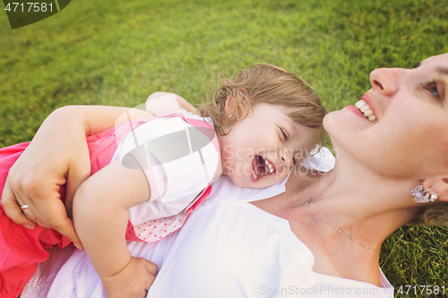 Image of mother and little daughter playing at backyard