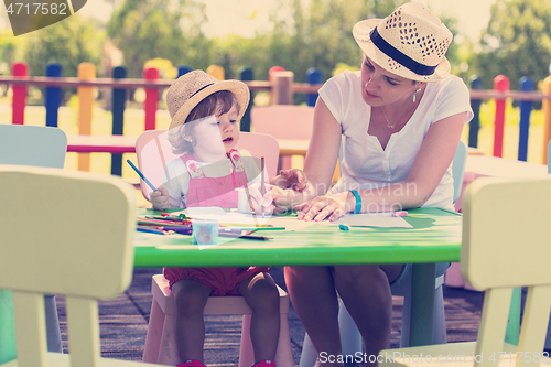 Image of mom and little daughter drawing a colorful pictures