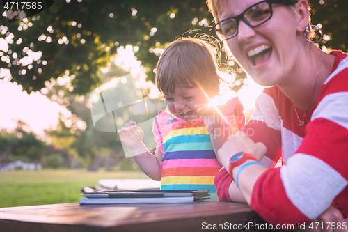 Image of mom and her little daughter using tablet computer