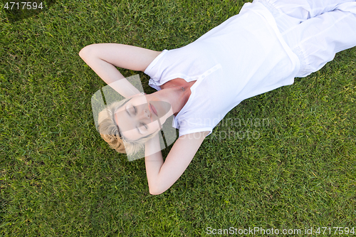 Image of top view of young woman relaxing on the grass