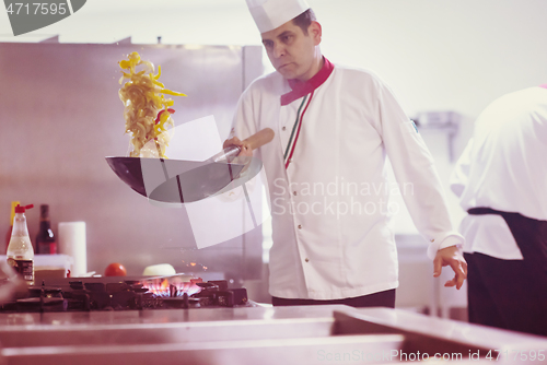 Image of chef flipping vegetables in wok