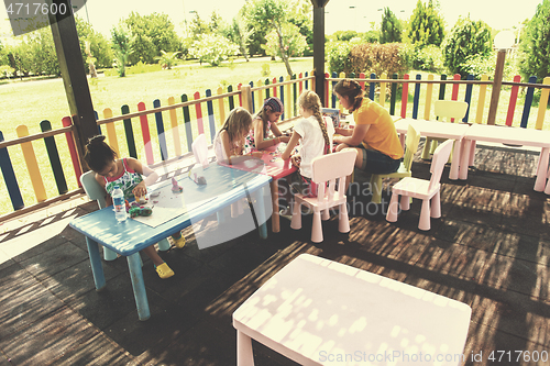 Image of mom and little daughter drawing a colorful pictures