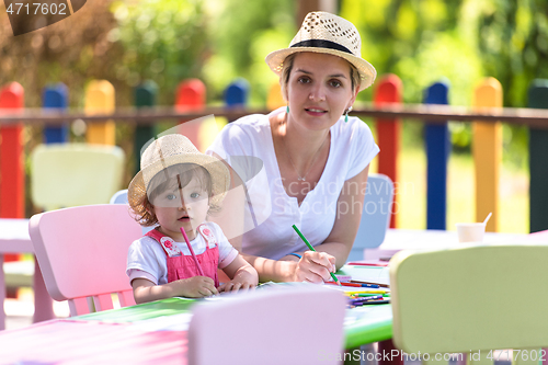 Image of mom and little daughter drawing a colorful pictures