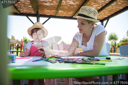 Image of mom and little daughter drawing a colorful pictures