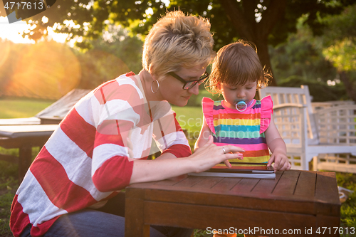 Image of mom and her little daughter using tablet computer