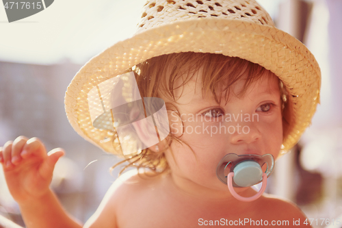 Image of tired little girl resting on sunbed