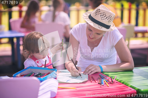 Image of mom and little daughter drawing a colorful pictures