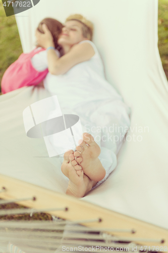 Image of mother and a little daughter relaxing in a hammock