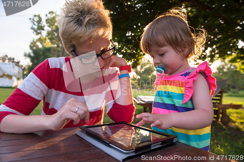 Image of mom and her little daughter using tablet computer