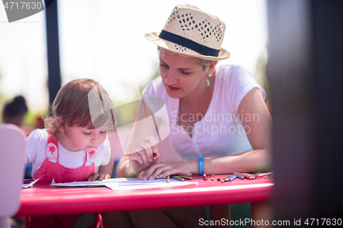 Image of mom and little daughter drawing a colorful pictures