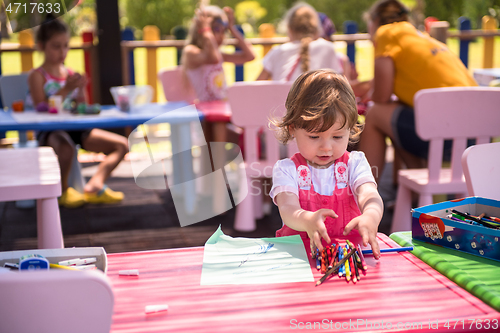 Image of little girl drawing a colorful pictures