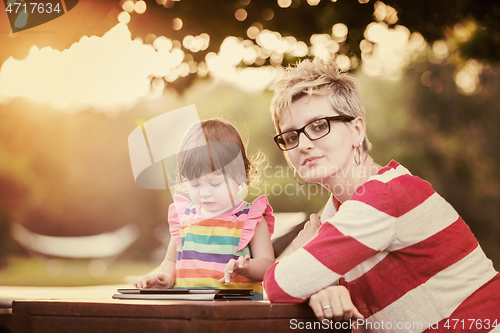 Image of mom and her little daughter using tablet computer