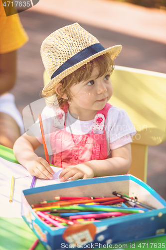 Image of little girl drawing a colorful pictures