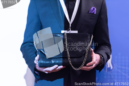 Image of young businessman holding leather bag