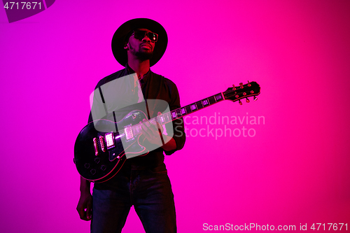 Image of Young african-american jazz musician playing the guitar