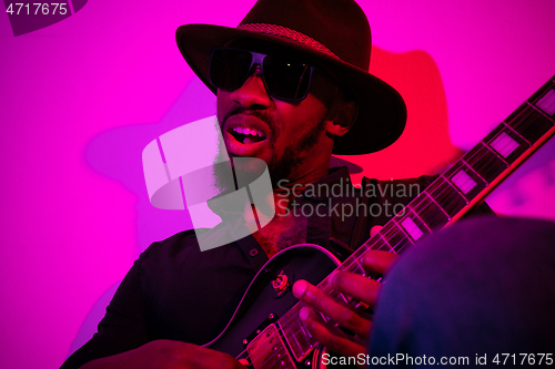 Image of Young african-american jazz musician playing the guitar