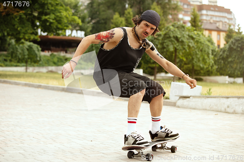 Image of Skateboarder doing a trick at the city\'s street in cloudly day