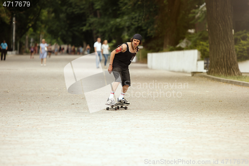 Image of Skateboarder doing a trick at the city\'s street in cloudly day