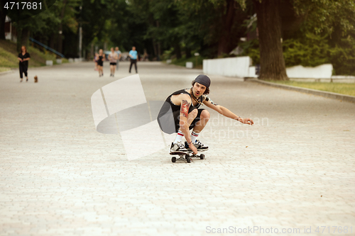 Image of Skateboarder doing a trick at the city\'s street in cloudly day