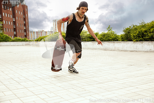 Image of Skateboarder doing a trick at the city\'s street in cloudly day