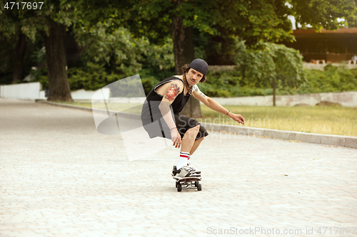 Image of Skateboarder doing a trick at the city\'s street in cloudly day