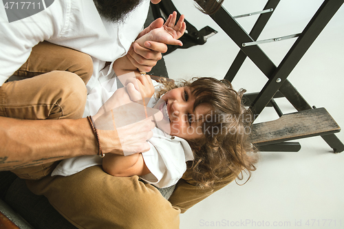 Image of Father playing with young son in their sitting room