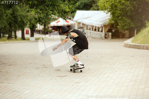 Image of Skateboarder doing a trick at the city\'s street in cloudly day