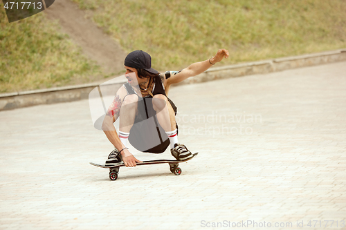 Image of Skateboarder doing a trick at the city\'s street in cloudly day