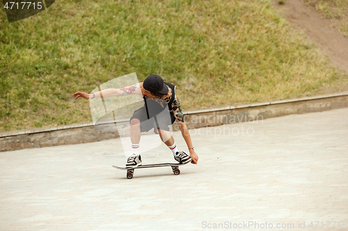 Image of Skateboarder doing a trick at the city\'s street in cloudly day