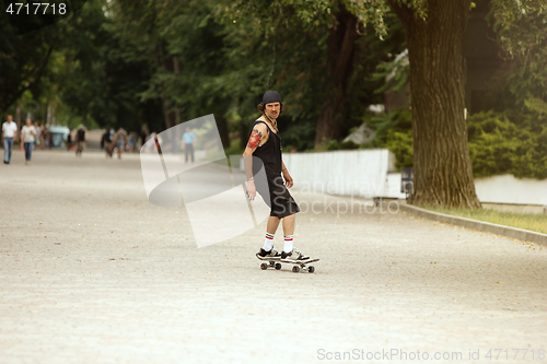 Image of Skateboarder doing a trick at the city\'s street in cloudly day