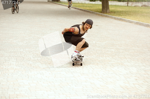 Image of Skateboarder doing a trick at the city\'s street in cloudly day