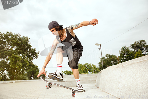 Image of Skateboarder doing a trick at the city\'s street in cloudly day