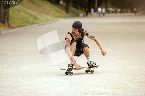 Image of Skateboarder doing a trick at the city\'s street in cloudly day