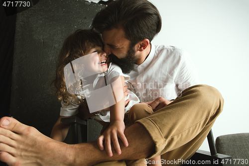 Image of Father playing with young son in their sitting room