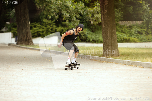 Image of Skateboarder doing a trick at the city\'s street in cloudly day