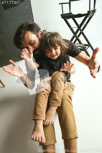 Image of Father playing with young son in their sitting room