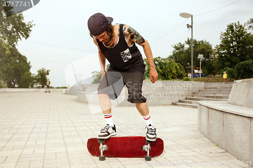 Image of Skateboarder doing a trick at the city\'s street in cloudly day